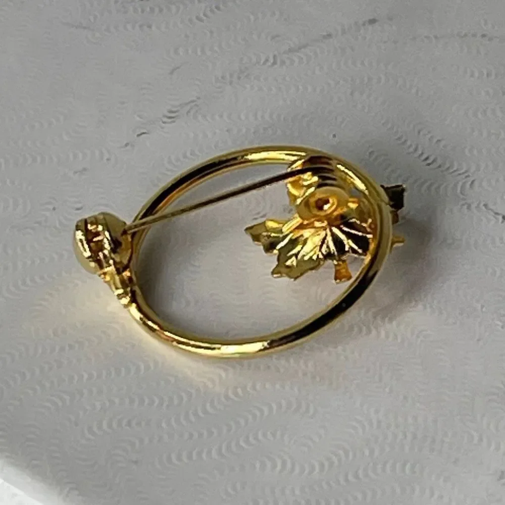 Vintage pearl adorned maple leaf open circle brooch.